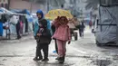 Sebelumnya, sistem pendidikan di Gaza berada di ambang kehancuran, dengan lebih dari 97% sekolah dilaporkan rusak atau hancur. Tampak dalam foto, seorang gadis kecil yang memegang payung pergi ke sekolah di Deir al-Balah, di Jalur Gaza tengah, pada 10 Desember 2025. (BASHAR TALEB/AFP)