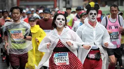 Peserta mengenakan kostum karakter kartun Mickey Mouse saat berlari selama Tokyo Marathon 2019 di Jepang, Minggu (3/3). Ajang marathon terbesar ini diikuti ribuan peserta dari mancanegara. (AFP Photo/Behrouz Mehri)