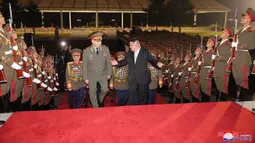 Kim Jong Un dan Sergei Shoigu berjalan melewati rudal balistik antarbenua yang sangat besar dan drone militer yang sebelumnya tak pernah diperlihatkan. (Korean Central News Agency/Korea News Service via AP)