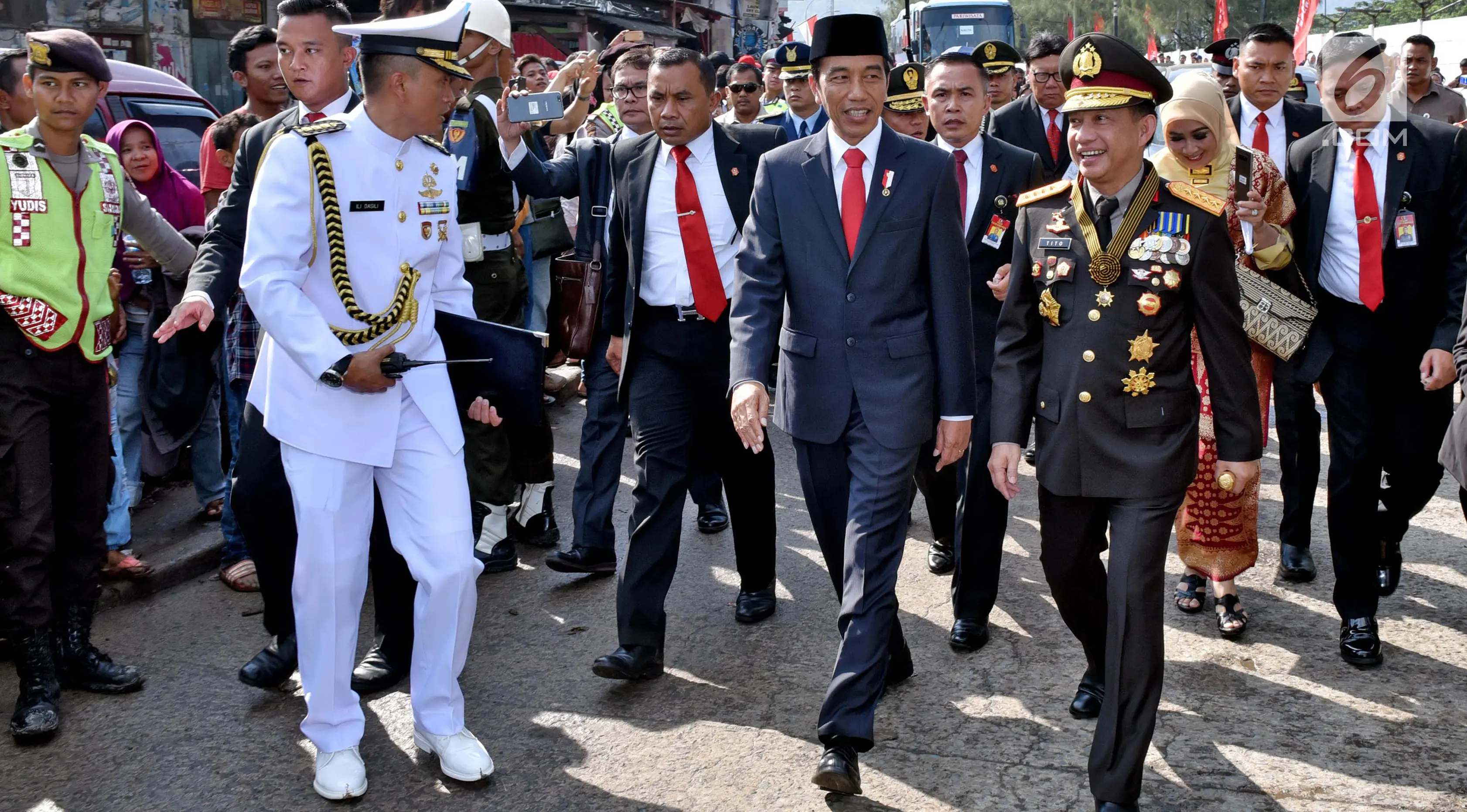 Presiden Joko Widodo didampingi Kapolri, Tito Karnavian beserta rombongan berjalan kaki menuju lokasi upacara HUT ke-72 TNI di Pelabuhan Indah Kiat, Banten (5/10). (Liputan6.com/Pool/Agus Suparto)