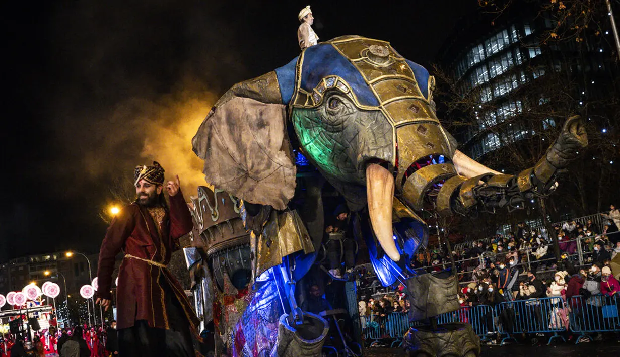 Anggota parade Cabalgata de Reyes di Madrid, Spanyol, 5 Januari 2022. Parade warna-warni ini dalam rangka merayakan Epiphany saat umat Kristen memperingati kunjungan Tiga Raja atau Tiga Orang Bijaksana ke bayi Yesus. (AP Photo/Bernat Armangue)