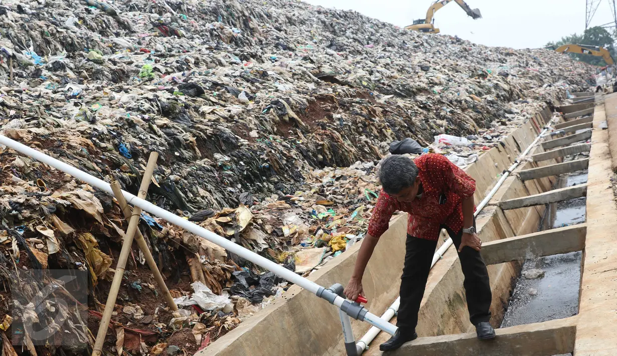 Peneliti mengecek pipa instalasi pengolahan bahan bakar gas metan di TPA Cipayung, Depok, Jumat (3/6). Pemanfaatan gas metan itu diharapkan mampu digunakan semaksimal mungkin untuk menjadi bahan bakar bagi warga sekitar. (Liputan6.com/Immanuel Antonius)