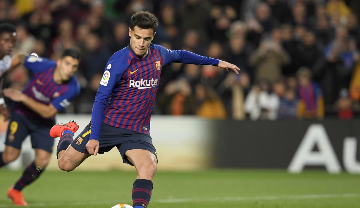 Phillippe Coutinho melepaskan tendangan penalti yang berbuah gol pada leg kedua Copa Del Rey yang berlangsung di stadion Nou Camp, Barcelona, Kamis (31/1). Barcelona menang 6-1 atas Sevilla. (AFP/Luis Gene)