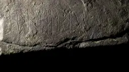 Runestone yang ditemukan di Tyrifjorden, Norwegia, diperlihatkan di Museum Sejarah Budaya di Oslo, pada 12 Januari 2023. Para arkeolog di Norwegia  menyatakan prasasti tersebut berusia hingga 2.000 tahun, berasal dari hari-hari awal sejarah misterius penulisan rahasia. (Javad Parsa/NTB Scanpix via AP)