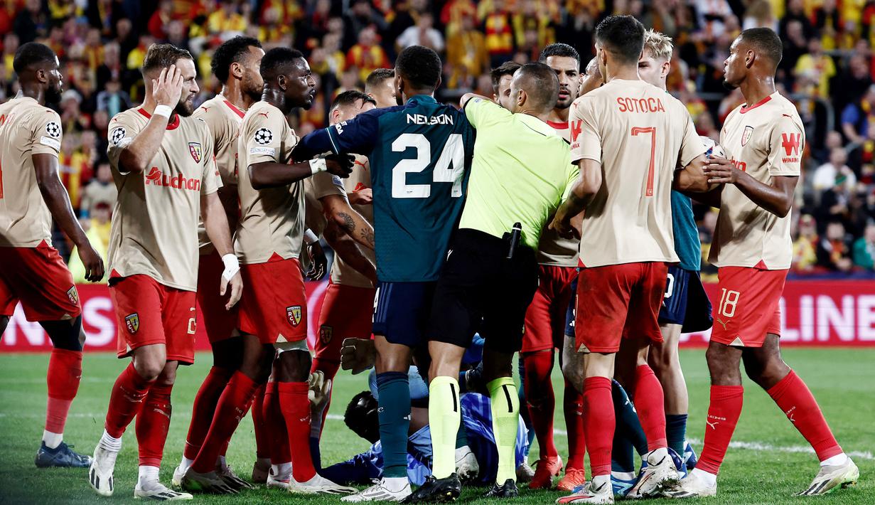 Wasit berusaha melerai keributan antara pemain RC Lens dengan pemain Arsenal pada laga Liga Champions di Stade Bollaert-Delelis, Rabu (4/10/2023). (AFP/Sameer Al-Doumy)