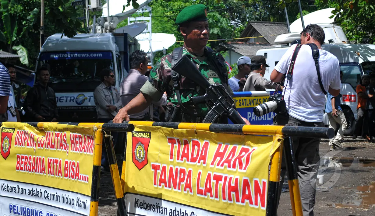 Seorang TNI tampak berjaga di sekitar pintu masuk dermaga Lapas Nusakambangan, Cilacap, Senin (27/4). Menjelang eksekusi mati terpidana narkoba, sterilisasi diberlakukan terhadap seluruh akses penyebrangan ke Nusakambangan. (Liputan6.com/Yoppy Renato)