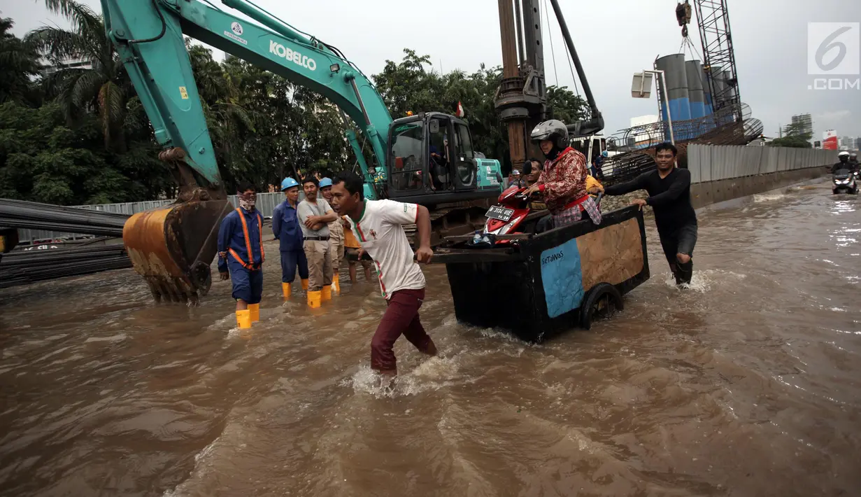 Sebuah sepeda motor diangkut menggunakan gerobak ketika banjir merendam di Jalan Boulevard Raya, Kelapa Gading, Jakarta, Kamis (15/2). Ketinggian banjir di kawasan ini mencapai 50 centimeter. (Liputan6.com/Arya Manggala)