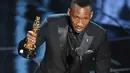 Aktor Mahershala Ali memberikan pidato kemenangan di atas podium Academy Awards ke-89 di Los Angeles, Minggu (26/2). Ali merupakan aktor muslim pertama yang memenangkan Oscar, ini merupakan prestasi pertamanya di tahun 2017 (Kevin Winter/Getty Images/AFP)