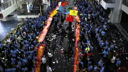 Sejumlah siswa melukan parade untuk menghilangkan stres jelang ujian tahunan "Gaokao" di Haikou, China (4/6). Mereka melakukan parade ini dua hari sebelum ujian tahunan "Gaokao" atau ujian masuk perguruan tinggi di China. (AFP)