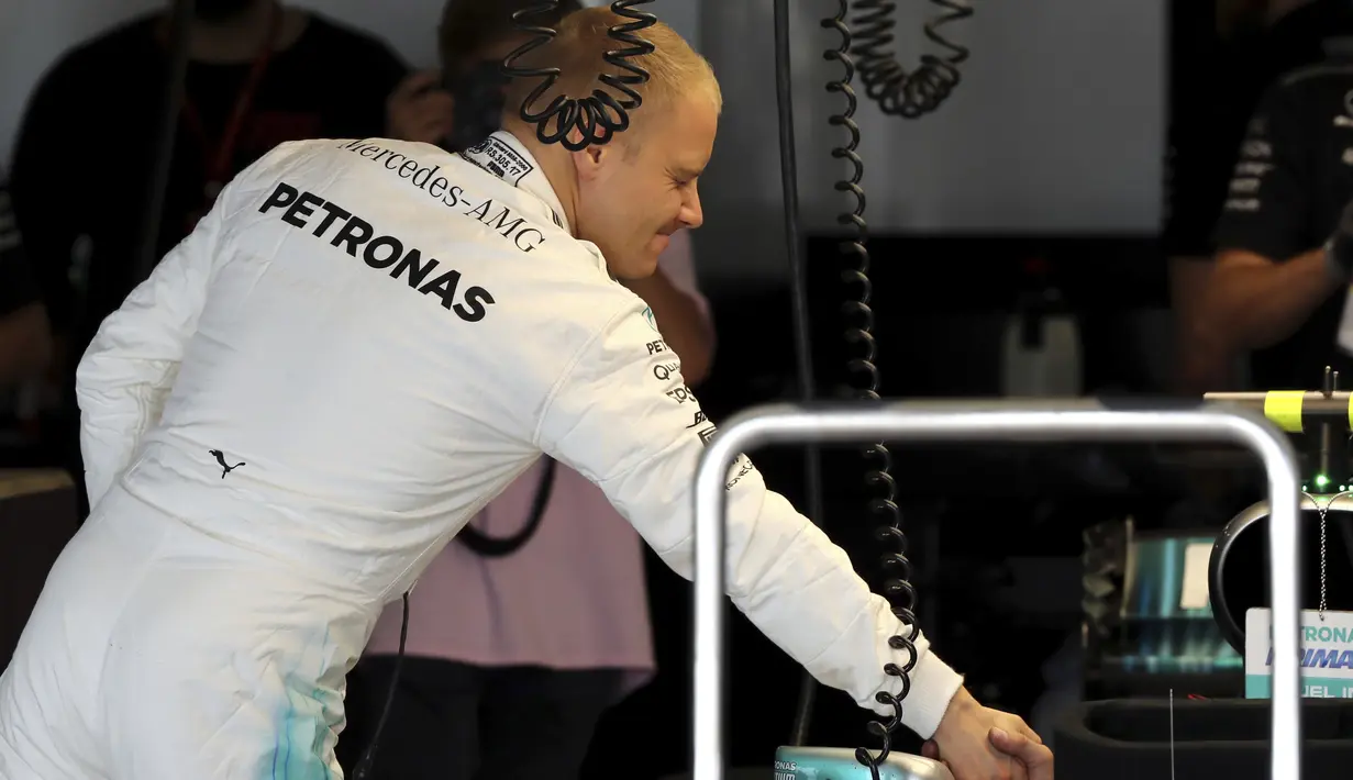 Pebalap Mercedes, Valtteri Bottas bersalaman dengan Lewis hamilton pada balapan F1 GP Jepang di Sirkuit Suzuka (7/10/2017). Bottas berapa di peringkat ketiga klasemen  dengan raihan 234 poin. (AP/Eugene Hoshiko)