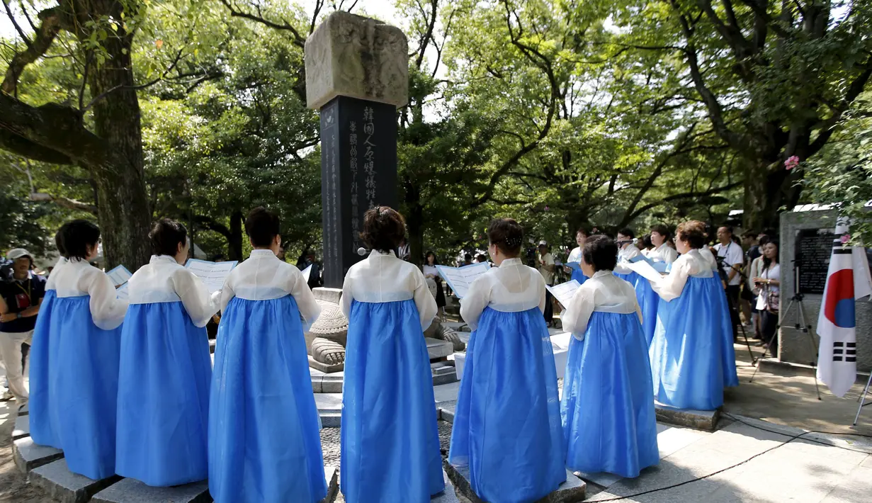 Sejumlah Wanita bernyanyi di depan Momumen Perdamaian yang didedikaasikan untuk memperingati 70 tahun  serangan bom terhadap Hiroshima, Jepang, Rabu  (5/8/2015). Bom atom di Hiroshima menewaskan hampir 140.000. (REUTERS/Toru Hanai)