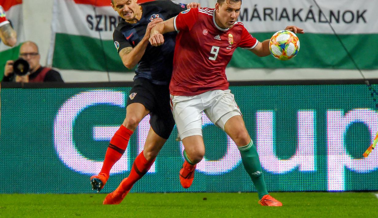 Duel antara Dejan Lovren dan Adam Szalai pada laga kedua babak kualifikasi Piala Eropa 2020 Grup E yang berlangsung di Stadion Groupama Arena, Budapest, Senin (25/3). Kroasia kalah 1-2 kontra Hungaria. (AFP/Attila Kisbenedek)