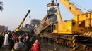 Warga saat melihat proses evakuasi kereta api yang mengalami kecelakaan fatal di Beni Suef, Kairo , (11/2). Badan kereta hingga keluar dari jalur saat alami kecelakaan. (REUTERS / Mohamed Abd El Ghany)