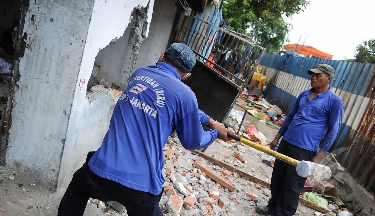 Petugas membongkar tembok rumah warga di kawasan Stasiun kemayoran, Jakarta, Senin (9/3/2015). Pembongkaran sembilan rumah warga yang masih berdiri di kawasan Stasiun kemayoran dilakukan oleh tim gabungan PT KAI. (Liputan6.com/Faizal Fanani)