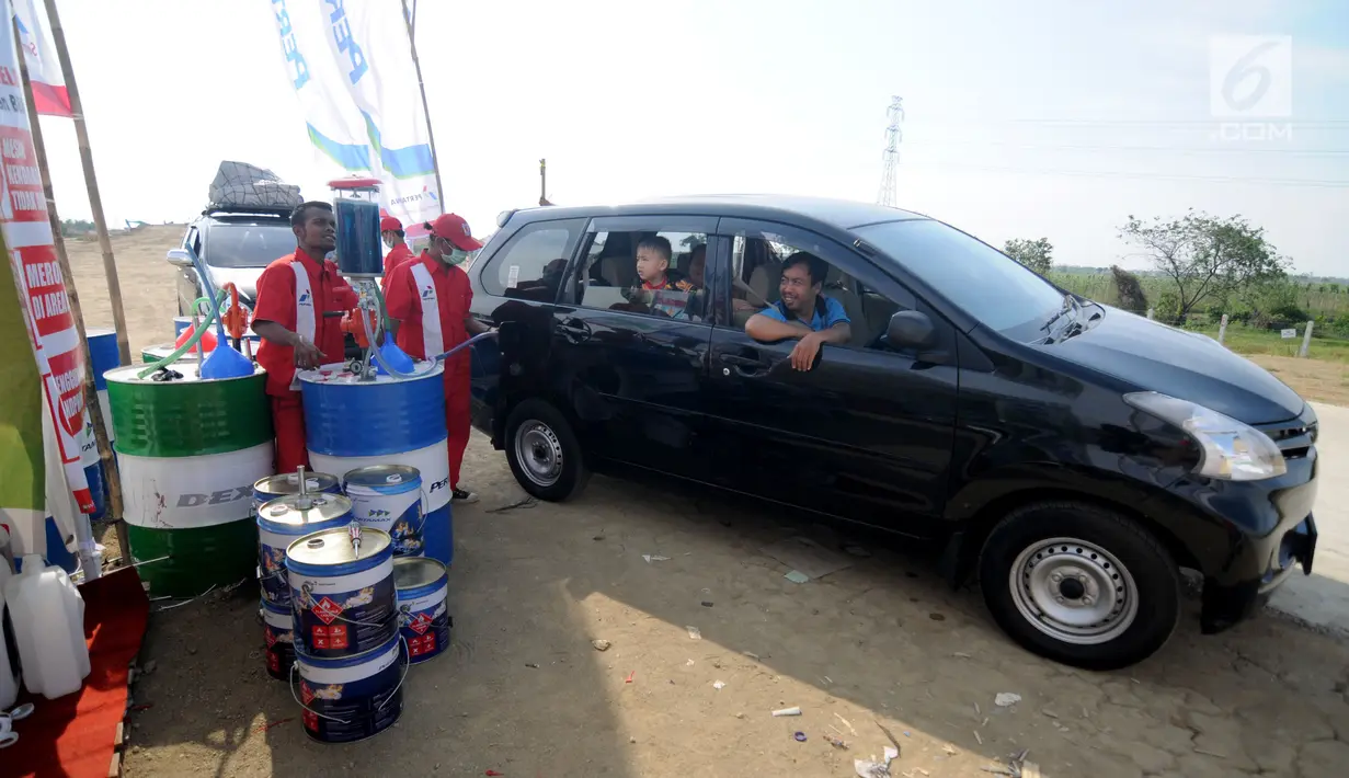 Petugas mengisi bahan bakar minyak (BBM) ke sebuah mobil pemudik di kios Pertamina jalan tol fungsional Brebes Timur-pemalang Km 275, Kabupaten Tegal, Jawa Tengah, Rabu (21/6). (Liputan6.com/Gempur M Surya)