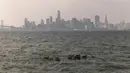 Sekelompok angsa berenang dekat Treasure Island saat lapisan asap akibat kebakaran hutan California Utara menyelimuti San Francisco, Amerika Serikat, Rabu (20/9/2023). (Stephen Lam/San Francisco Chronicle via AP)