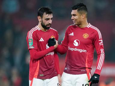 Pemain Manchester United, Bruno Fernandes dan Casemiro, merayakan kemenangan atas Leicester City pada pertandingan babak 16 besar Carabao Cup di Stadion Old Trafford, Kamis (31/10/2024). (AP Photo/Dave Thompson)