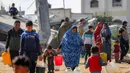 Sekitar 67% fasilitas air dan sanitasi di kota Gaza dilaporkan hancur atau rusak akibat konflik berkepanjangan antara Israel dan Hamas. Tampak dalam foto, warga mengisi wadah air dari tangki air portabel di kamp pengungsi Palestina Maghazi, Jalur Gaza tengah pada Rabu 11 Februari 2026. (Eyad BABA/AFP)