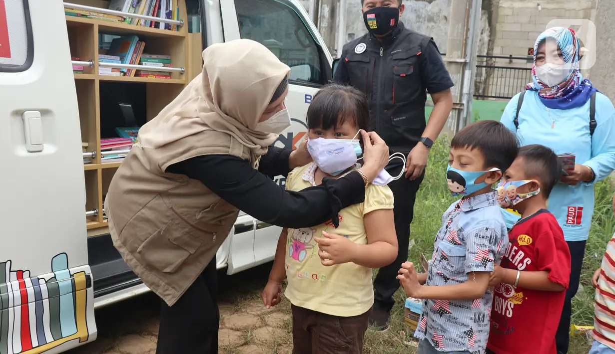 Karyawan Askrindo memberikan masker kain kepada anak-anak korban banjir di Kantor Kecamatan Cilamaya Wetan, Cikampek Jumat (12/02/2021). Askrindo melakukan aksi tanggap bencana banjir di dua lokasi di Karawang dengan memberikan bantuan sembako dan makanan siap saji. (Liputan6.com/Pool/Askrindo)