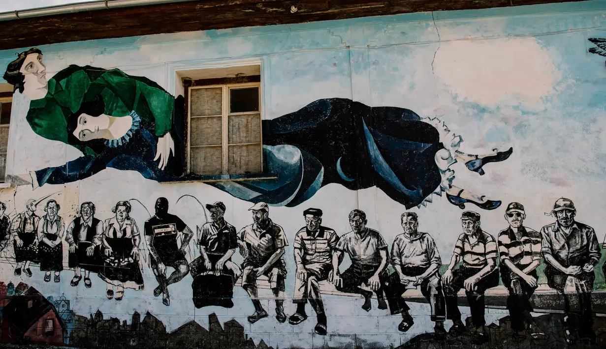 Lukisan mural "Over the city" karya Marc Chagall menghiasi dinding rumah desa Staro Zhelezare di Bulgaria, 4 Agustus 2018. Desa Staro Zhelezare ini adalah salah satu dari banyak desa yang termiskin di Uni Eropa. (AFP/Dimitar DILKOFF)