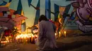 Seorang perempuan meletakkan lilin di depan mural bergambar Kobe Bryant dan putrinya Gianna Bryant di Los Angeles, Senin (27/1/2020). Pemain basket legendaris NBA Kobe Bryant bersama putrinya, Gianna yang berusia 13 tahun meninggal dunia dalam kecelakaan helikopter pada Senin (27/1). (Apu GOMES/AFP)