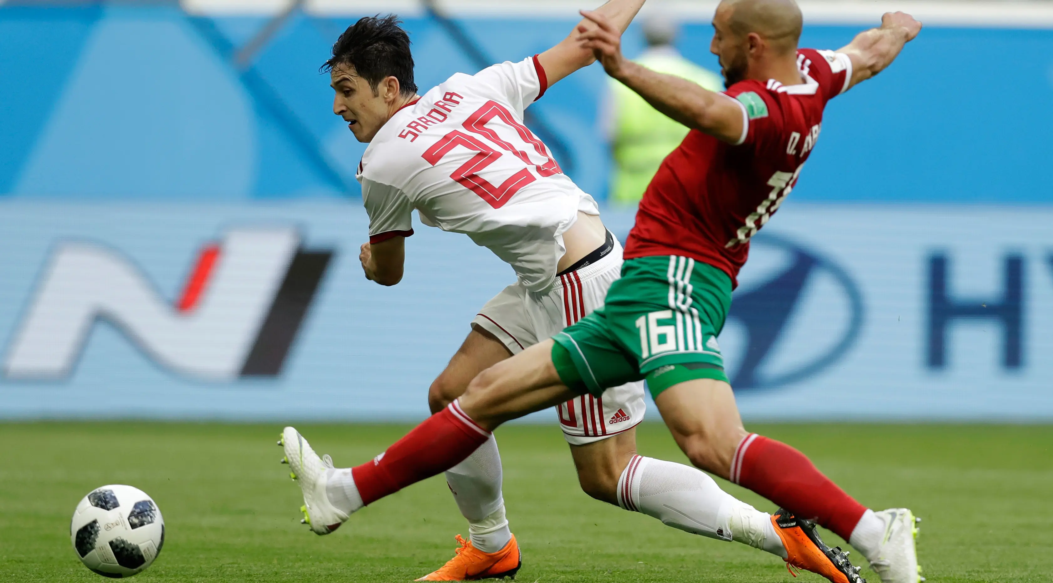 Pemain Iran Sardar Azmoun berusaha melewati pemain Maroko Noureddine Amrabat saat bertanding pada grup B Piala Dunia 2018 di St Petersburg Stadium, Rusia, (15/6). Iran menang tipis 1-0 berkat gol bunuh diri Aziz Bouhaddouz. (AP Photo/Andrew Medichini)