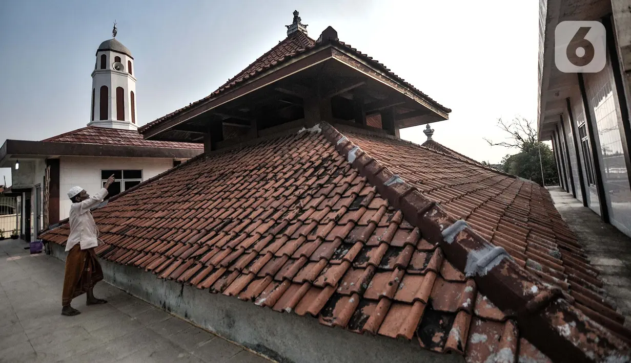 Kohar menunjukkan puncak atap bebentuk mahkota (memolo) yang masih asli di Masjid Jami Al Alam, Cilincing, Jakarta, Kamis (22/4/2021). Tercatat dalam sejarah, masjid ini menjadi masjid tertua di Jakarta bersamaan dengan kembarannya, yakni Masjid Al Alam Marunda. (merdeka.com/Iqbal S.Nugroho)