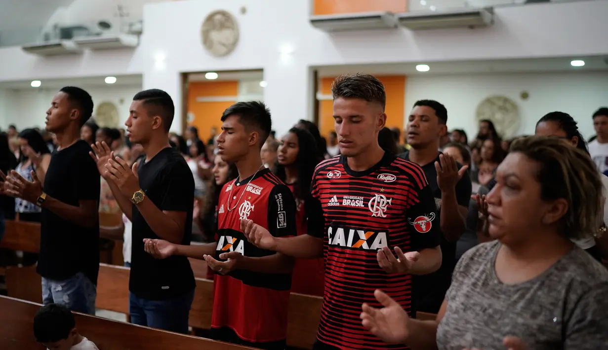 Para pemain muda Flamengo berdoa dalam Misa peringatan untuk para korban kebakaran di sebuah akademi sepakbola Brasil, di Rio de Janeiro, Brasil (8/2). (AP Photo/Leo Correa)