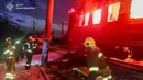Dalam foto yang dirilis oleh Layanan Darurat Ukraina pada 27 Januari 2026 ini, para penyelamat Ukraina berupaya memadamkan api di gerbong kereta api setelah serangan udara di lokasi yang tidak diungkapkan di wilayah Kharkiv, di tengah invasi Rusia ke Ukraina. Serangan pesawat nirawak (drone) Rusia menghantam sebuah kereta penumpang sipil di wilayah Kharkiv, Ukraina. (Handout/UKRAINIAN EMERGENCY SERVICE/AFP)
