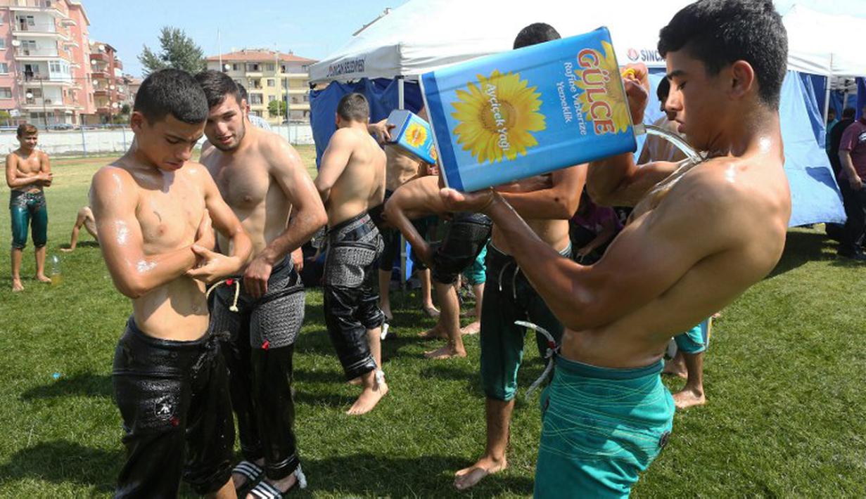 Turnamen gulat dengan melumaskan oli ke tubuh peserta secara rutin di gelar di Ankara, Turki. Tahun ini merupakan yang ketujuh kalinya di gelar, tepatnya Sabtu, 1 Agustus 2015. Peserta diwajibkan melumaskan oli sebelum bertanding. (AFP Photo/Adem Altan)