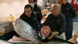 Pedagang Yamayuki memisahkan kepala dan ekor ikan tuna sirip biru seberat 405 kilogram pada lelang tuna di pasar ikan Tsukji, (5/1). Lelang ikan dengan harga mencapai miliaran rupiah ini rutin digelar setiap awal tahun. (AP Photo / Eugene Hoshiko)