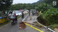 Kendaraan melintas dekat lokasi jalan longsor di Desa Bondawuna, Kabupaten Bone Bolango, Gorontalo, Selasa (30/4/2019). Hujan yang mengguyur wilayah Kabupaten Bone Bolango mengakibatkan empat desa di Kecamatan Suwawa Selatan, dan Bulango Timur Bone Bolango banjir. (Liputan6.com/Arfandi Ibrahim)