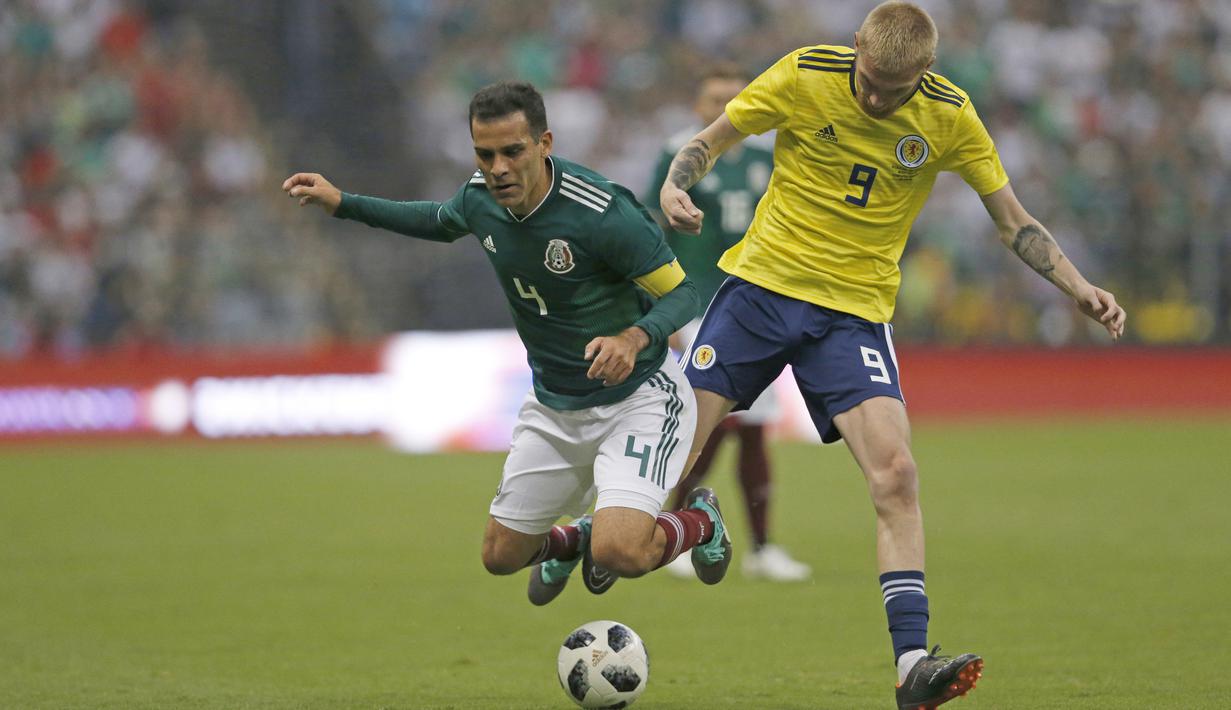 Pemain Meksiko, Rafael Marquez (kiri) saat berebut bola dengan pemain Skotlandia, Oliver McBurnie pada laga uji coba di Azteca Stadium, Meksiko City, (2/6/2018). Meksiko menang 1-0.  (AP/Rebecca Blackwell)