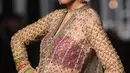 Seorang model mengenakan busana rancangan desainer Dnnus Dlrar selama Pantene Hum Bridal Couture Week di Lahore, Minggu (9/12). Kreasi gaun pengantin yang ditampilkan didominasi kain sari yang menjadi ciri khas wanita Pakistan. (ARIF ALI / AFP)