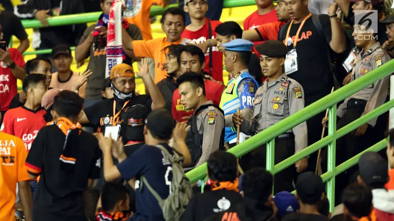 Polisi menertibkan suporter Persija Jakarta pada laga melawan Perserui, Juni lalu. Ke depannya, Macan Kemayoran akan menambah jumlah personel keamanan. 