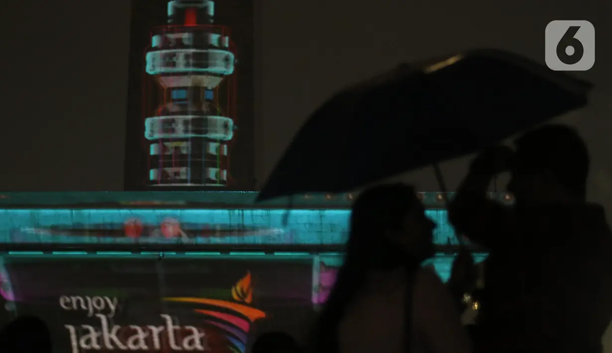 Penampilan video mapping saat malam pergantian tahun di kawasan Monumen Nasional, Jakarta, Selasa (31/12/2019). Meski Jakarta diguyur hujan sejak Selasa (31/12) sore, warga tetap mendatangi kawasan Monas untuk merayakan malam pergantian tahun. (Liputan6.com/Helmi Fithriansyah)