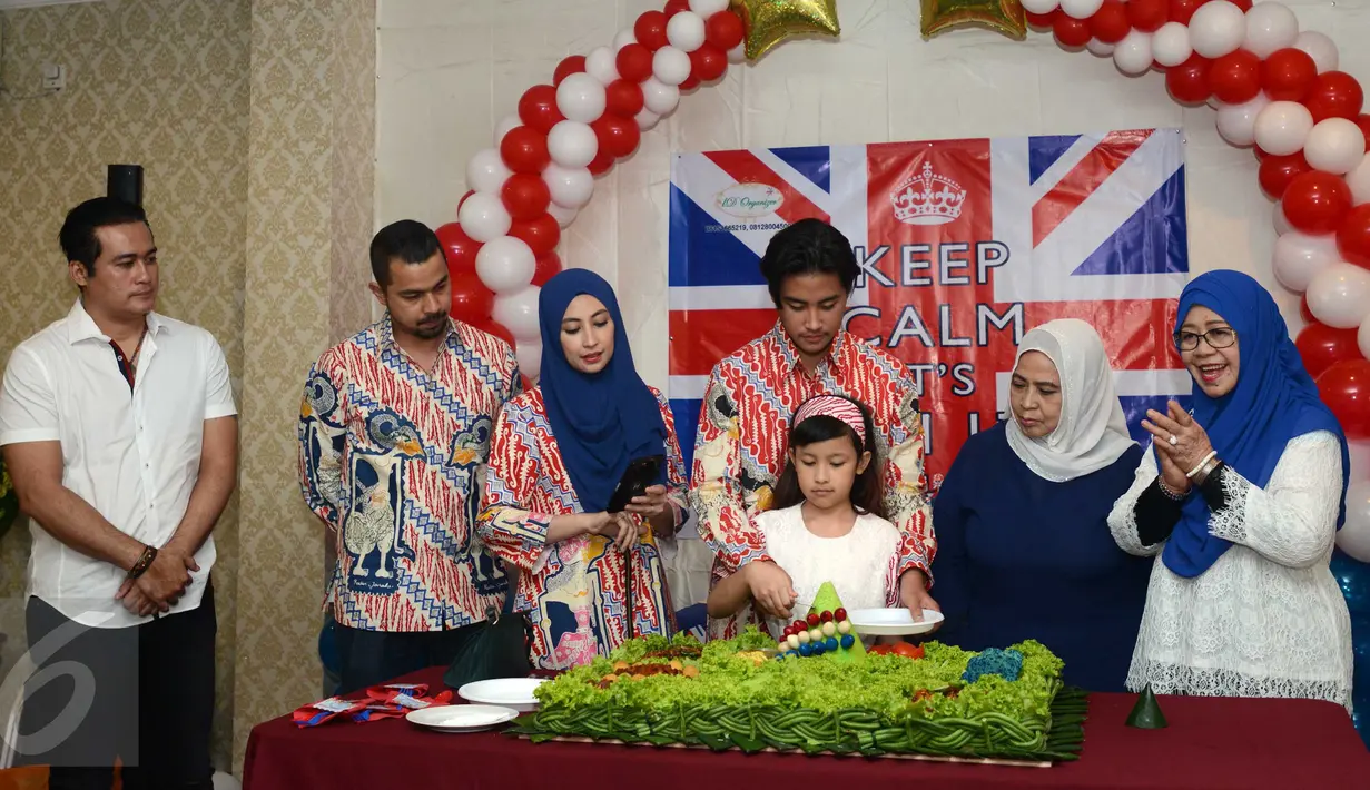 Muhammad Rafi bersama adiknya memotong tumpeng saat acara Ulang Tahun Rafi ke-17, Jakarta, Sabtu  (24/12). Dua ayahnya hadir yaitu Adjie Pangestu dan Sultan Djorghi. (Liputan6.com/Herman Zakharia)
