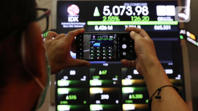Seorang pria mengambil gambar layar yang menampilkan informasi pergerakan saham di gedung Bursa Efek Indonesia, Jakarta, Senin (8/6/2020). Seiring berjalannya perdangan, penguatan IHSG terus bertambah tebal hingga nyaris mencapai 1,50 persen. (Liputan6.com/Angga Yuniar)