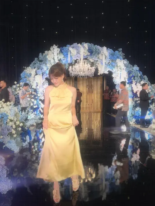 Cassandra Lee tampil menawan dengan halter dress yang simpel, namun klasik dengan cara yang tak berlebihan. Ia menambahkan beberapa aksesori seperti gelang dan high heels keemasan yang serasi. [Foto: Instagram/cassandraslee]
