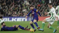 Gelandang Barcelona, Lionel Messi, berusaha melewati gelandang Real Betis, Andre Gomes, pada laga La Liga Spanyol di Stadion Benito Vilamarin, Sevilla, Minggu (21/1/2018). Betis kalah 0-5 dari Barcelona. (AFP/Cristina Quicler)