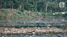 Warga memancing di Situ Pengarengan yang penuh sampah dan sedimentasi lumpur, Depok, Minggu (10/10/2021). Sampah dan sedimentasi lumpur menjadi pemandangan baru di Situ Pengarengan akibat proyek normalisasi yang dikerjakan oleh DPUPR Kota Depok tidak berjalan. (merdeka.com/Iqbal S Nugroho)