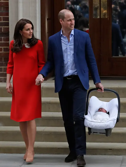 Pangeran William dan Kate Middleton bergandengan tangan saat meninggalkan Rumah Sakit St Mary's di London, Senin (23/4). Di luar dugaan, William dan Kate yang berniat untuk kembali ke Kensington Palace memamerkan kemesraannya. (AP/Kirsty Wigglesworth)