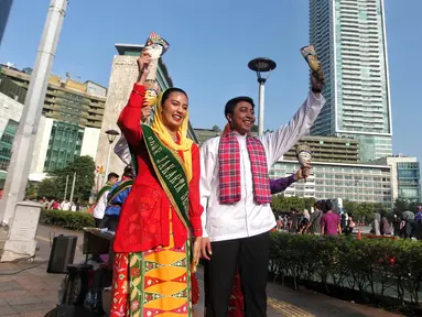 Abang None Jakarta melakukan tarian lenggang Jakarta saat sosialisasi pemilihan Abang None Jakarta 2025 di sekitar kawasan Bundaran Hotel Indonesia, Jakarta, Minggu (8/6/2025). (Liputan6.com/Angga Yuniar)