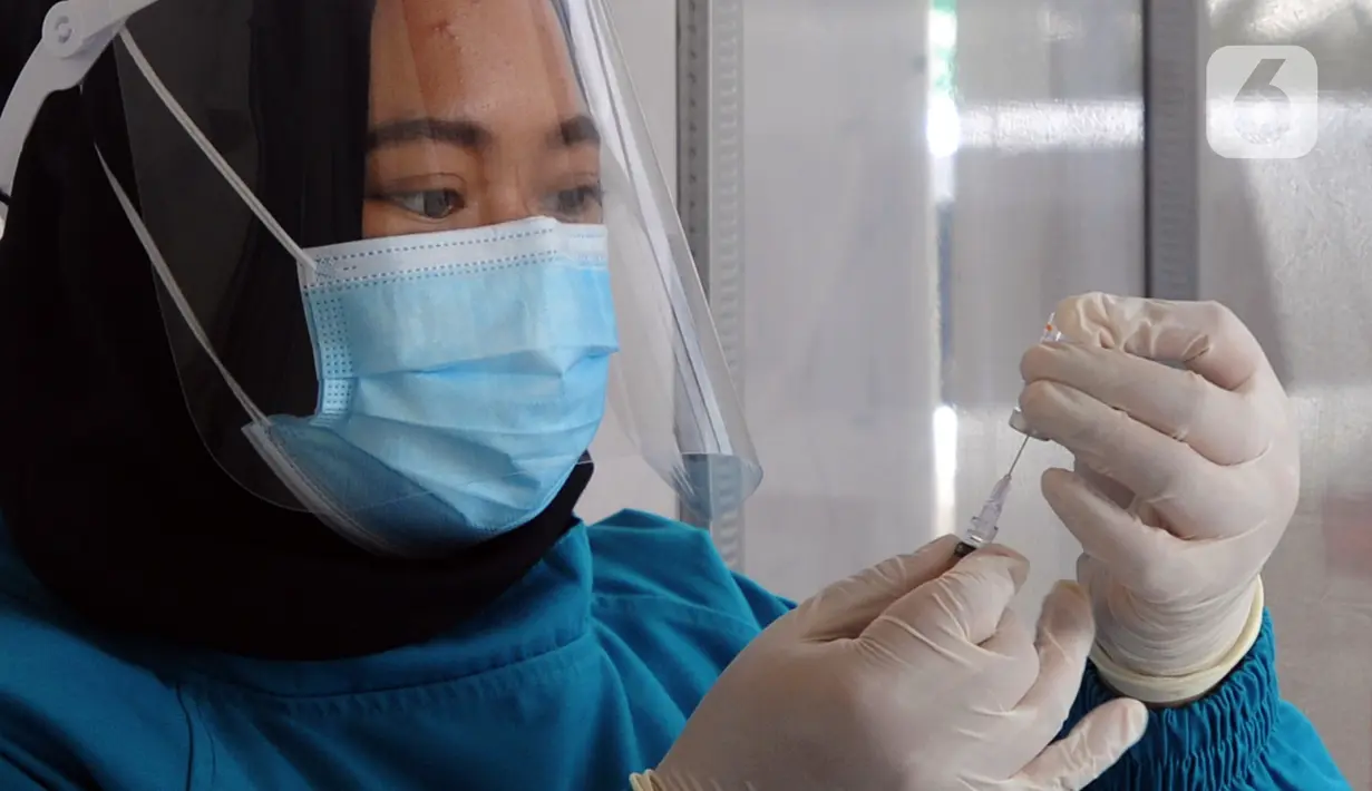 Dokter menyiapkan vaksin virus corona COVID-19 produksi Sinovac saat kegiatan vaksinasi di Puskemas Jagakarsa, Jakarta Selatan, Kamis (14/1/2020). Sejumlah Puskesmas di Jabodetabek mulai melakukan vaksinasi COVID-19 pada hari ini. (merdeka.com/Arie Basuki)