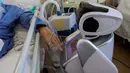 Pasien positif virus corona berinteraksi dengan robot di rumah sakit 'Ospedale di Circolo', di Varese, Italia pada 8 April 2020. Sebanyak enam unit robot yang tampak seperti manusia dan berjalan di atas roda ini membantu kinerja staf medis dalam merawat pasien virus corona Covid-19. (AP/Luca Bruno)