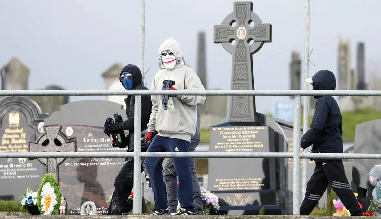 <p>Foto-foto menunjukkan empat pemuda di daerah Creggan yang sebagian besar berhaluan nasionalis Irlandia melemparkan bom molotov ke sebuah kendaraan lapis baja polisi, yang dilalap api di satu sisi. (AP Photo/Peter Morrison)</p>