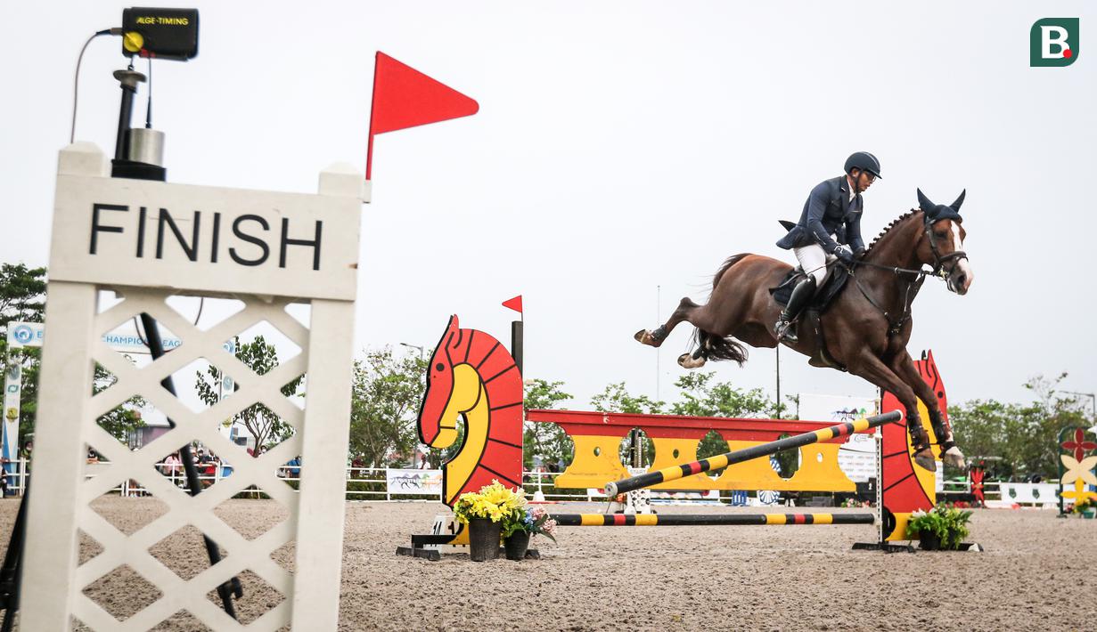 Atlet berkuda tim W-Equestrian, Erwin M. Yoga beraksi pada Show Jumping 140 cm saat ajang Solidarity Equestrian Challange 2022 yang berlangsung di Jakarta International Equestrian Park, Jakarta Timur, Minggu (30/01/2022). (Bola.com/Bagaskara Lazuardi)