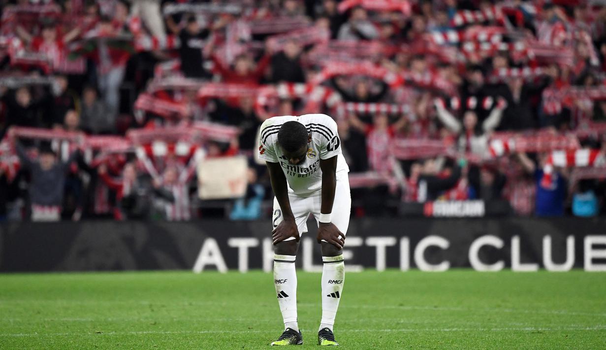 Pemain Real Madrid, Antonio Rudiger tertunduk lesu setelah kalah dari Atheltic Bilbao pada laga lanjutan Liga Spanyol 2024/2025 di San Mames Stadium, Bilbao, Spanyol, Kamis (05/12/2024) dini hari WIB. (AFP/Ander Gillenea)