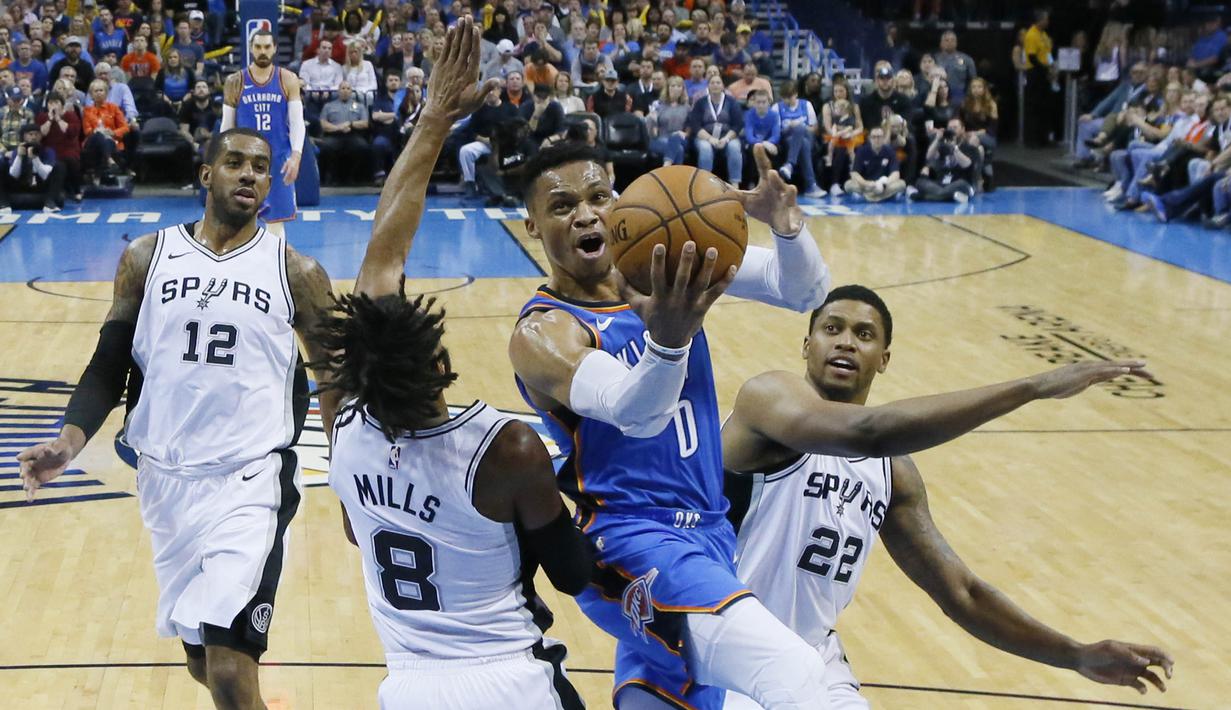 Pebasket San Antonio Spurs, Patty Mills dan Rudy Gay, berusaha menghadang pebasket Oklahoma City Thunder, Russell Westbrook, pada laga NBA di Chesapeake Energy Arena, Minggu (11/3/2018). Thunder menang 104-94 atas Spurs. (AP/Sue Ogrocki)