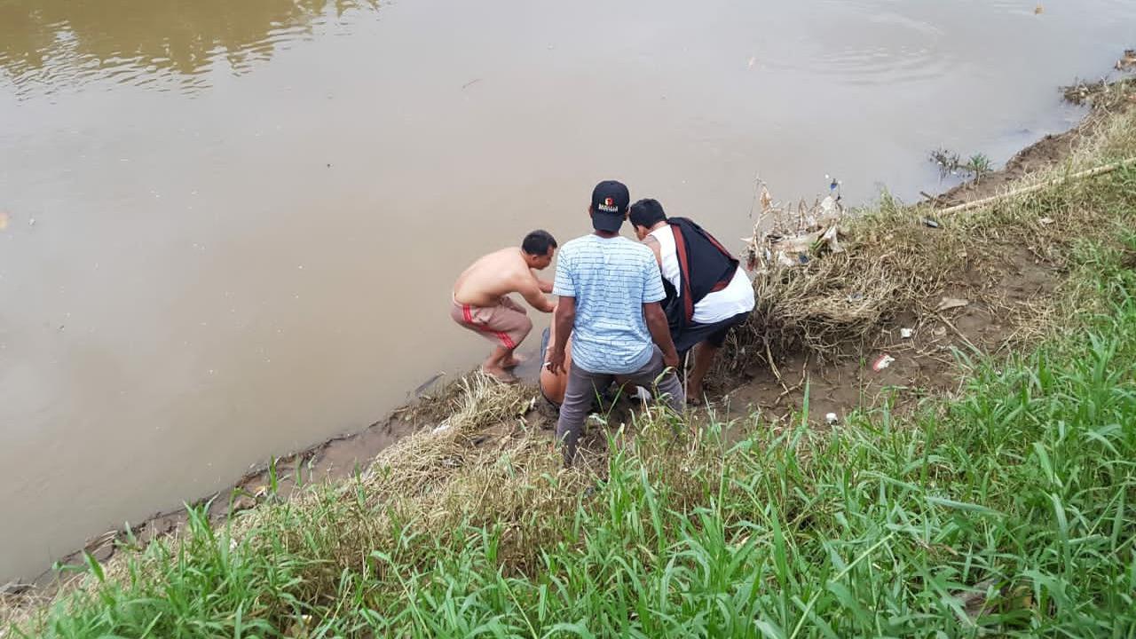 Warga mengevakuasi jasad bayi yang ditemukan di pinggiran Kali Bekasi, di depan kawasan industri Cipendawa, Rawalumbu, Bojong Menteng. Foto: Istimewa